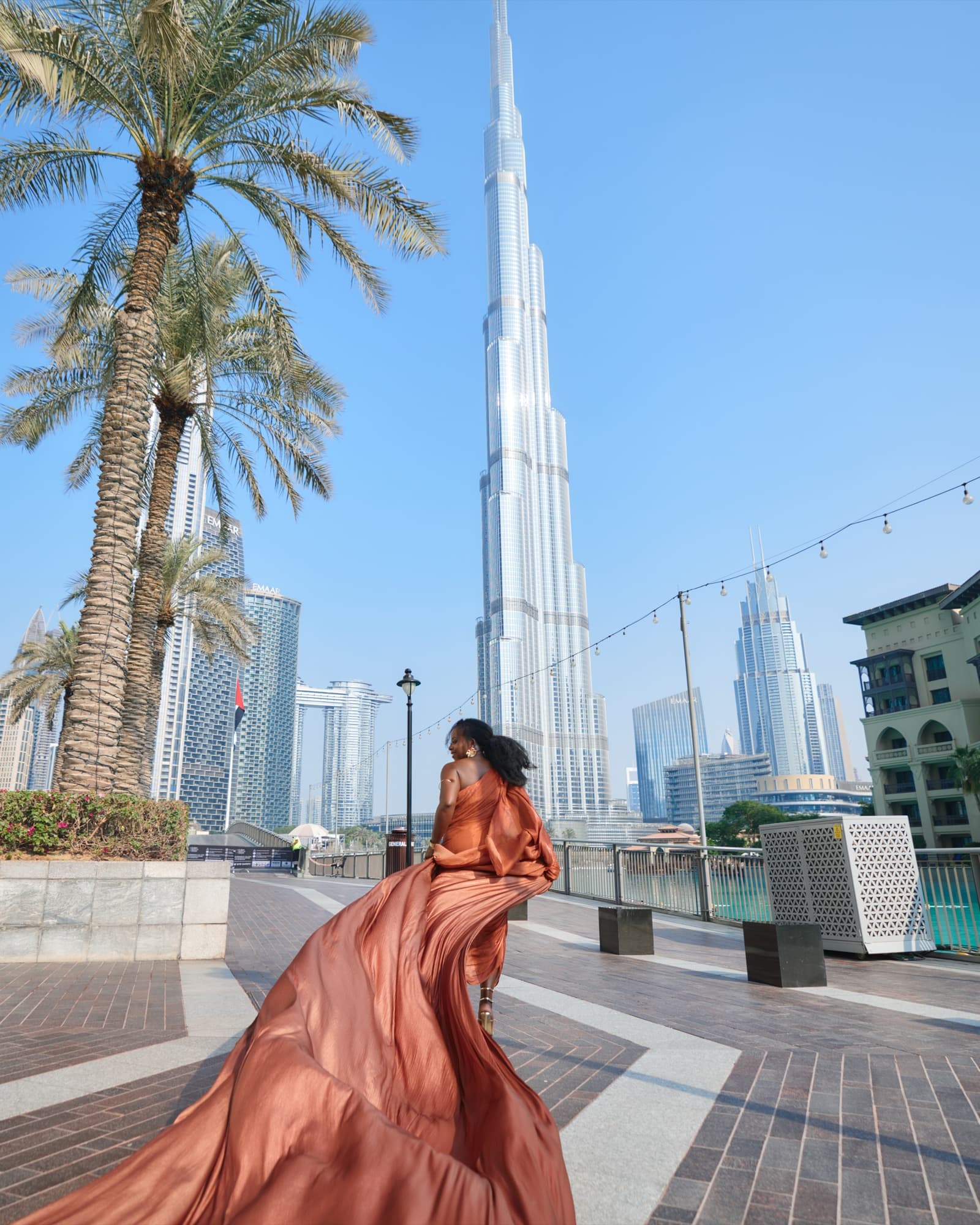 Portrait in a flowing copper dress with the Burj Khalifa skyline.